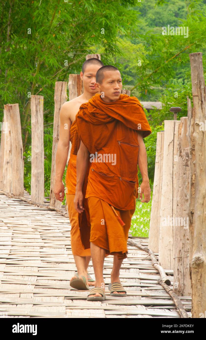 Thailand: Buddhistische Mönche, die die Bambusbrücke überqueren, Wat Phu Sama, Su Tong Pae Bamboo Bridge, Mae Hong Son. Die Bambusbrücke erstreckt sich 500 Meter über den Fluss Mae Sa Nga und Rizefields. Die Brücke ermöglicht Mönchen den Zugang von Wat Phu Sama zum kleinen Dorf im Westen. Stockfoto