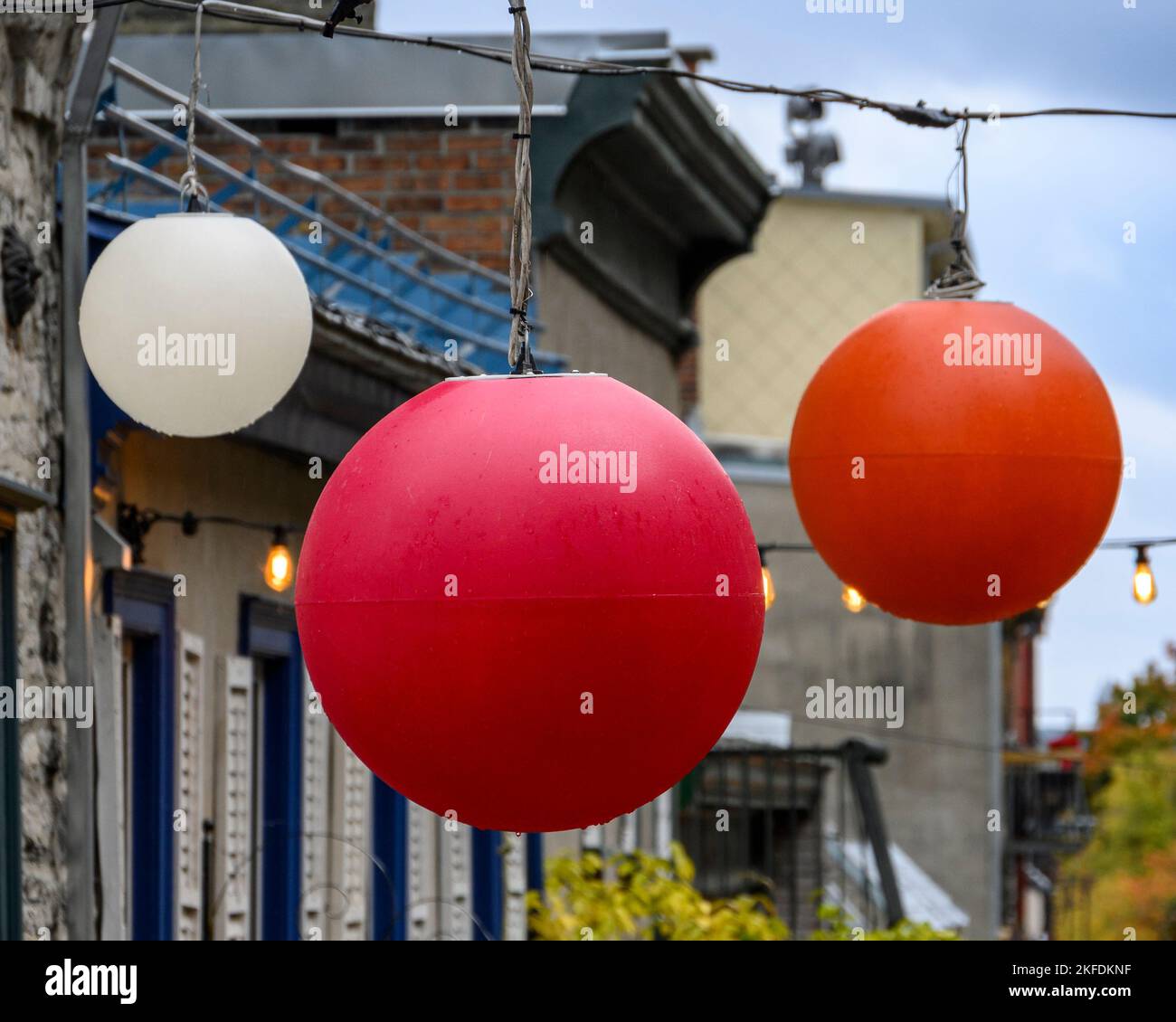 Drei bunte Globen hängen über einer Straße in der Altstadt von Quebec Stockfoto