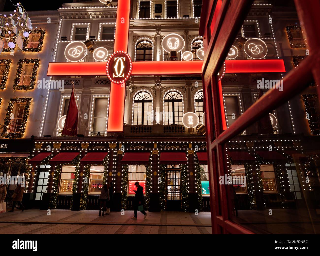 Weihnachtlich beleuchtetes Display mit Band-Effekt im Cartier Jewellers with Red Phone Box, New Bond Street, London. Stockfoto