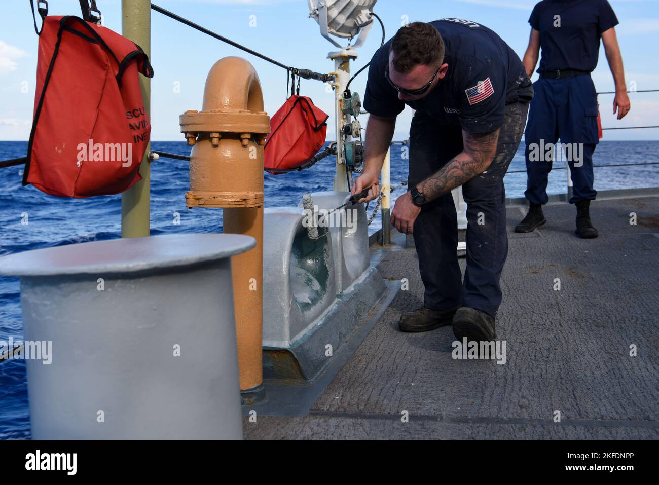 Der US-Küstenwache-Petty Officer der Klasse 2. Stephen Reiss übermalt die Deckbeschläge an Bord der USCGC Mohawk (WMEC 913), während er am 10. September 2022 im Atlantischen Ozean unterwegs war. Die Armaturen auf dem Deck müssen neu gestrichen werden, wenn es notwendig ist, Korrosion oder Verschlechterung der Serviceleistungen zu verhindern. Stockfoto