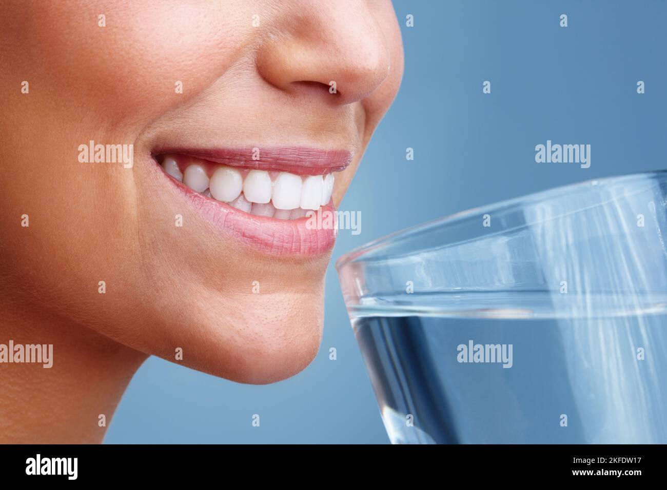 Detailansicht einer Frau, die ein Glas Wasser trinkt. Detailansicht einer jungen hübschen Frau, die ein Glas Wasser trinkt. Stockfoto