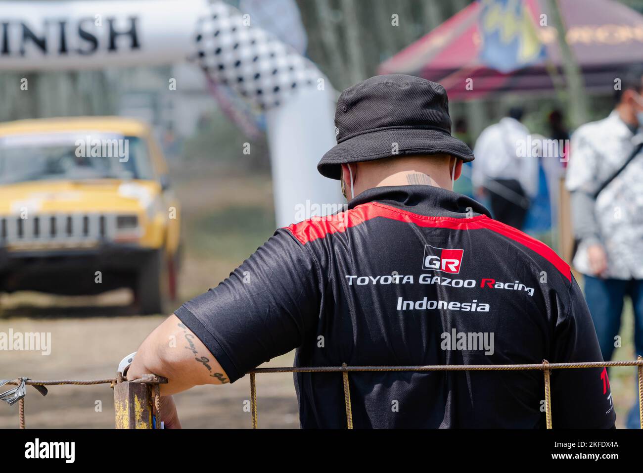 Die Crew des Toyota Gazoo Racing Teams lehnt sich an einen Metallzaun mit Bokeh oder unscharfem Hintergrund Stockfoto