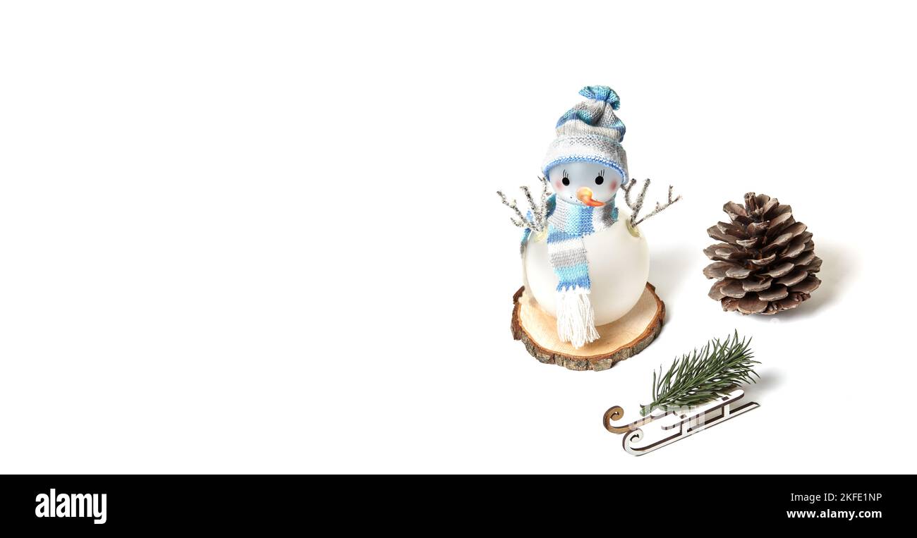 Schneemann, Kegel, Schlitten, Fichtenzweig isoliert auf weißem Hintergrund, Kopierraum. Nahaufnahme des Schneemanns mit Hut und Schal, Weihnachtsfest und Neujahr Stockfoto