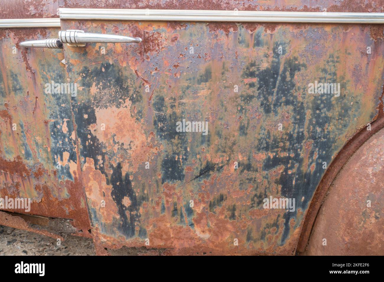 Rost und alte Farbe Nahaufnahme auf Oldtimer-Oldtimer-Türen im Freien als abstrakter Hintergrund, Hintergrund oder Tapete Stockfoto