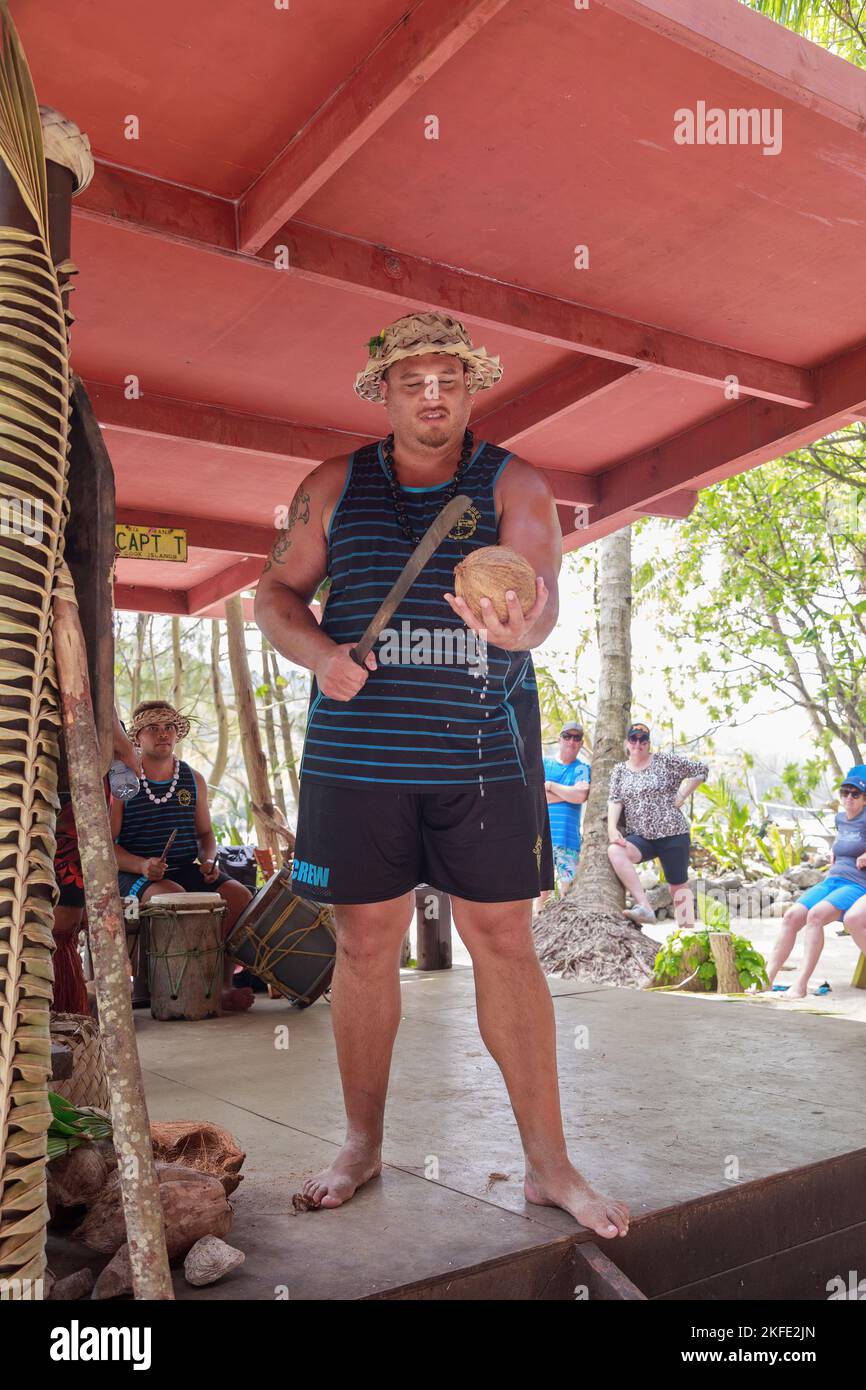 Ein polynesischer Mann demonstriert bei einer Kulturshow auf Rarotonga, Cook Islands, wie man eine Kokosnuss mit einer Machete öffnet Stockfoto