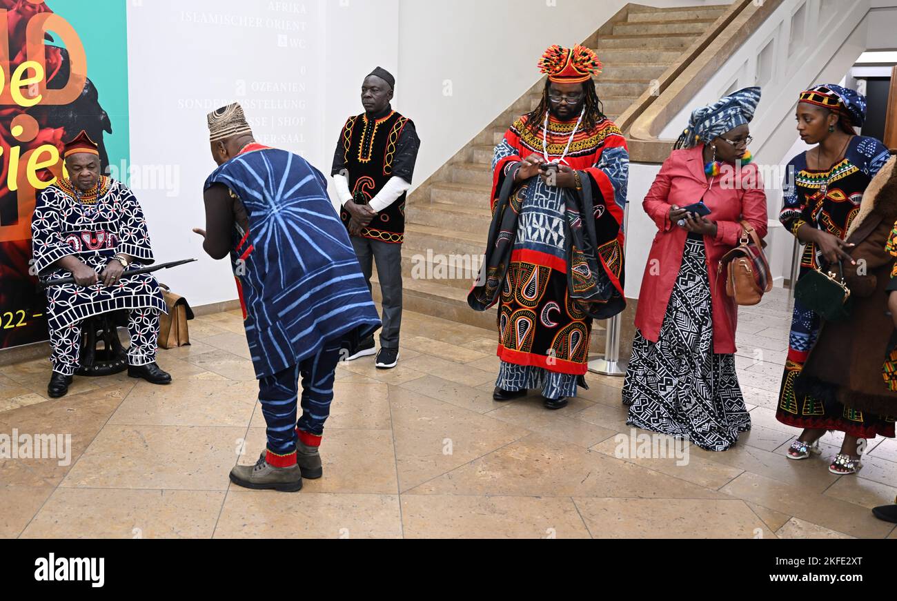 Stuttgart, Deutschland. 17.. November 2022. König Fon Sehm Mbinglo I (l) vom NSO aus dem Nordwesten Kameruns wird von seinem Gefolge bei seinem Besuch im Linden Museum angesprochen. Im Ethnologischen Museum in Stuttgart sind mehrere Objekte ausgestellt, die den NSO-Bewohnern des nordwestlichen Kameruns zugeschrieben werden. Die Künstlerin Sylvie N. hat als Vertreterin ihres Volkes einen offiziellen Rückgabeantrag gestellt, der vom Land Baden-Württemberg geprüft werden muss. Quelle: Bernd Weißbrod/dpa/Alamy Live News Stockfoto