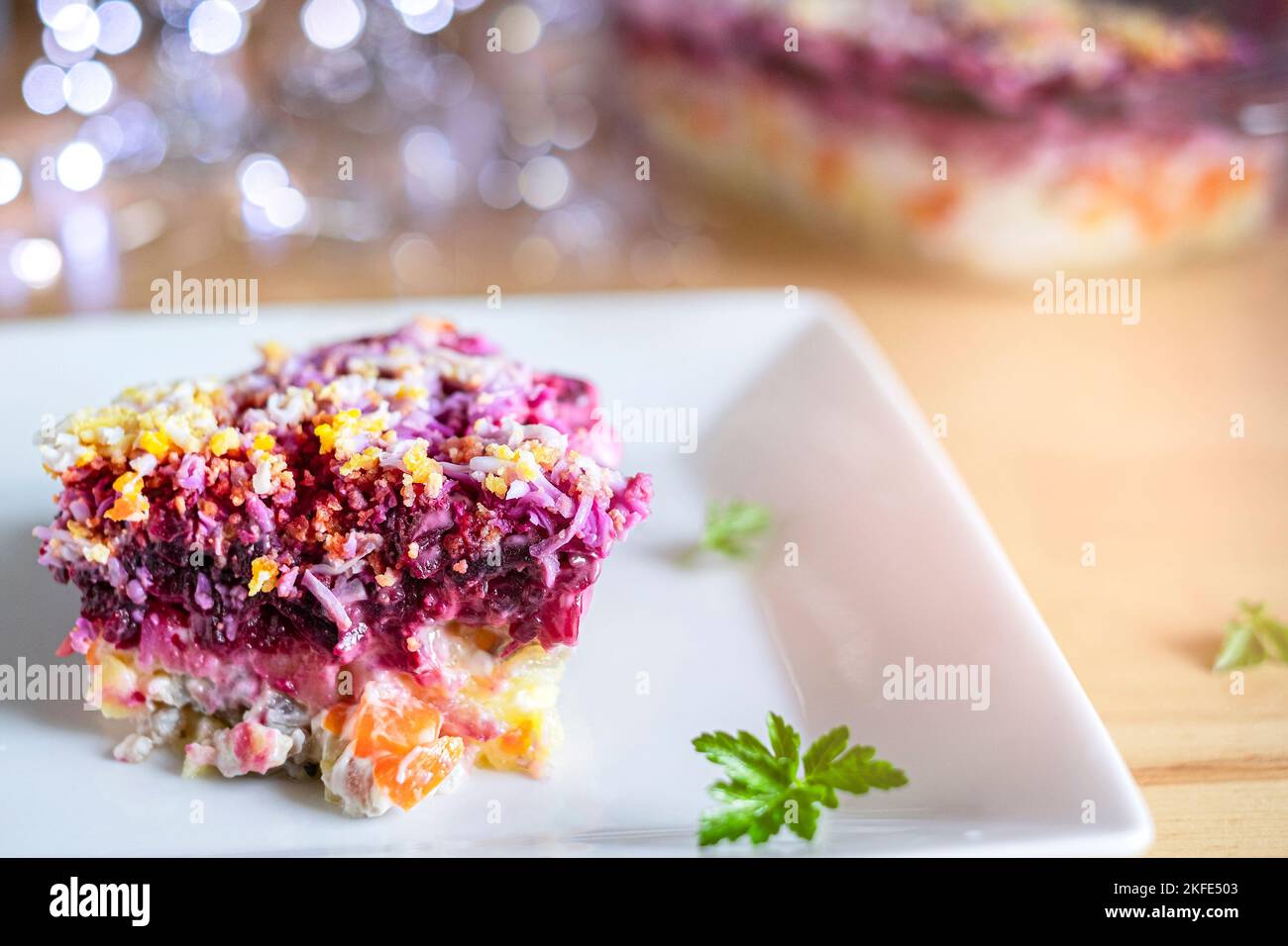 Mehrlagiger Salathering unter dem Pelzmantel auf dem Tisch. Portion von traditionellem russischen Salat mit Hering, Rüben, Karotten und Ei Stockfoto