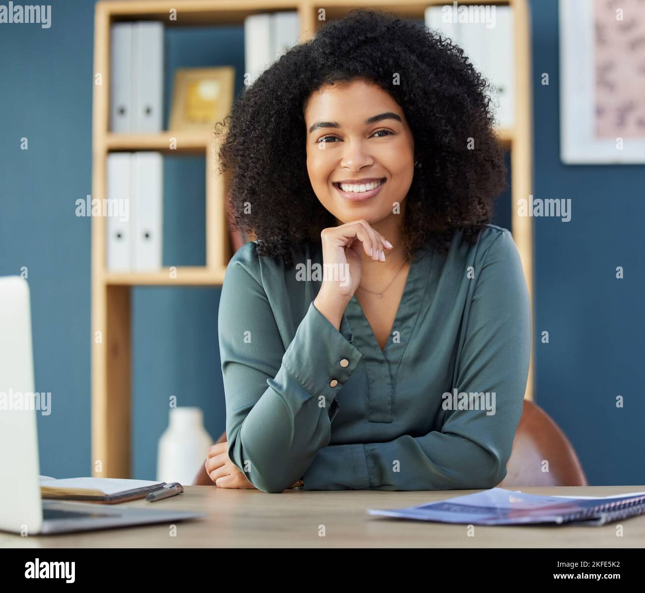Gesicht, glücklich und Personalwesen mit einer schwarzen Geschäftsfrau, die an einem Schreibtisch in ihrem Büro sitzt. Porträt, Lächeln und Interview mit einer weiblichen HR-Managerin Stockfoto