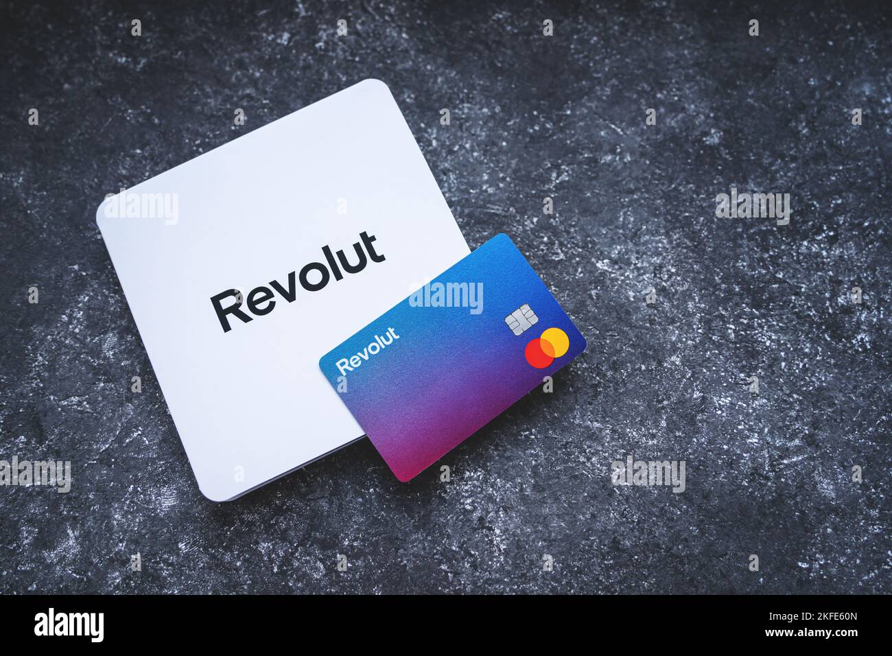 Revolut Bankkarte mit dem weißen Umschlag. Neu gestaltete Revolut Mastercard ohne Kartendetails auf konkretem Hintergrund. Krakau, Polen - 11. November 2022. Stockfoto