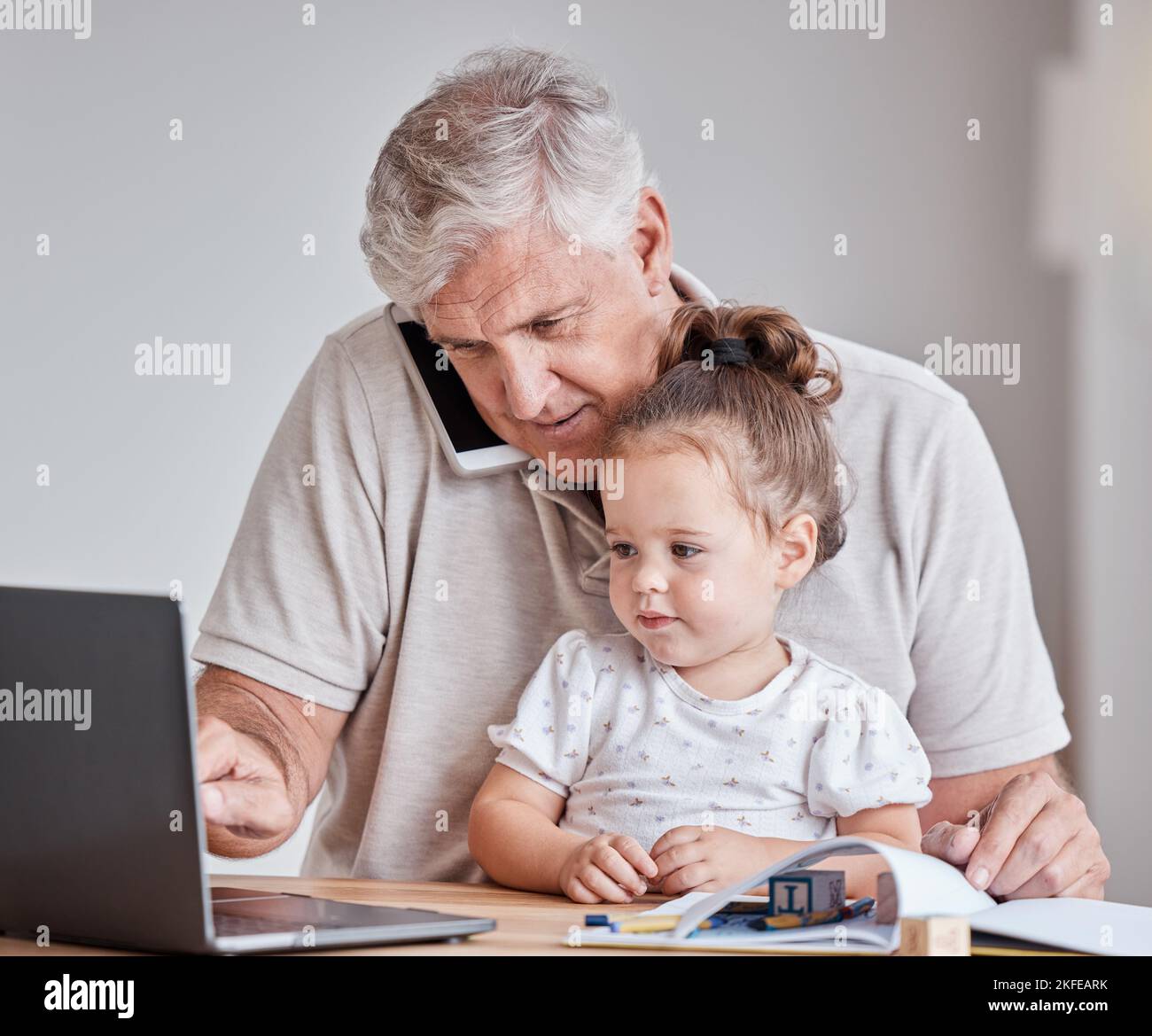 Älterer Mann, Kind und Telefonanruf während der Arbeit am Laptop für die Fernarbeit mit Großvater Babysitter Mädchen im Heimbüro. Männlich mit Kind als Familie in Stockfoto