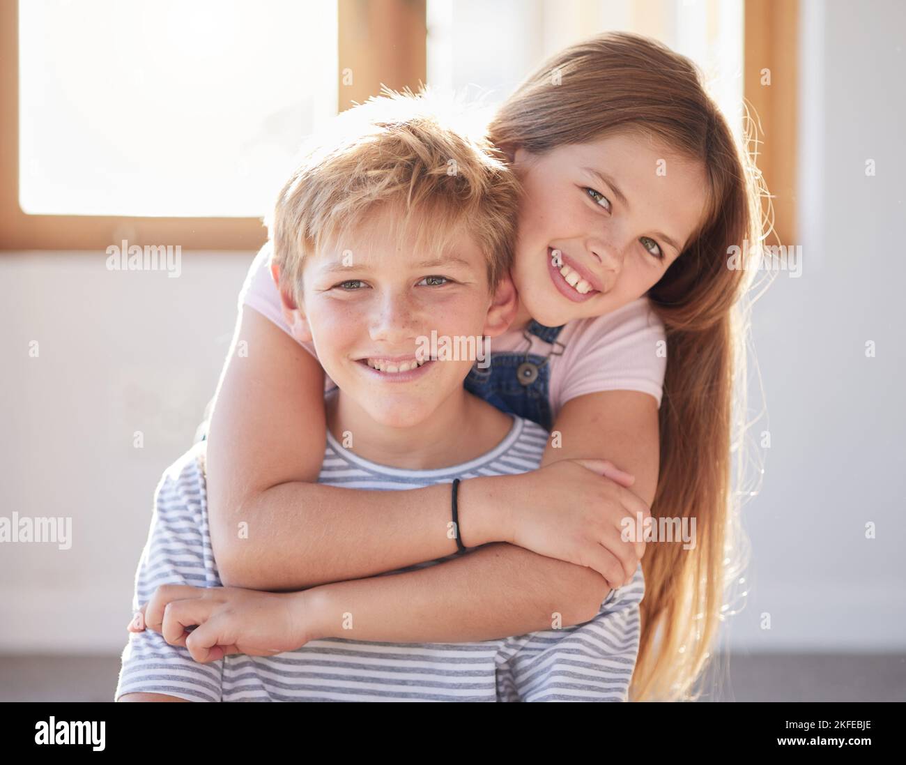 Familie, Umarmung und Porträt von Mädchen und Jungen in einem Wohnzimmer, Kleben und glücklich, während die Zeit miteinander genießen. Gesicht, glückliche Familie und Geschwister Stockfoto