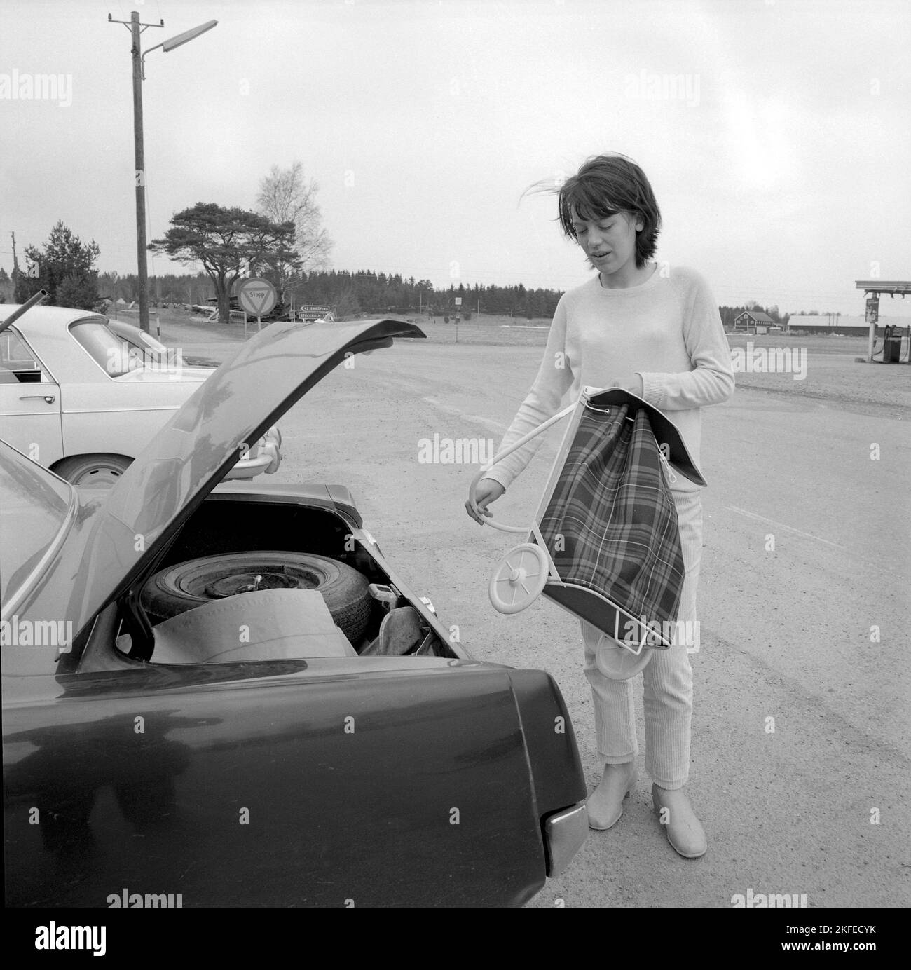 Einkaufen in der 1960s. Eine Dame hat ihr Auto im Supermarkt geparkt und nimmt ihren Warenkorb auf dem Parkplatz heraus. Ein Neuheitsartikel, der ursprünglich aus den USA kam. Schweden april 14 1966 Conard Ref. 5236 Stockfoto