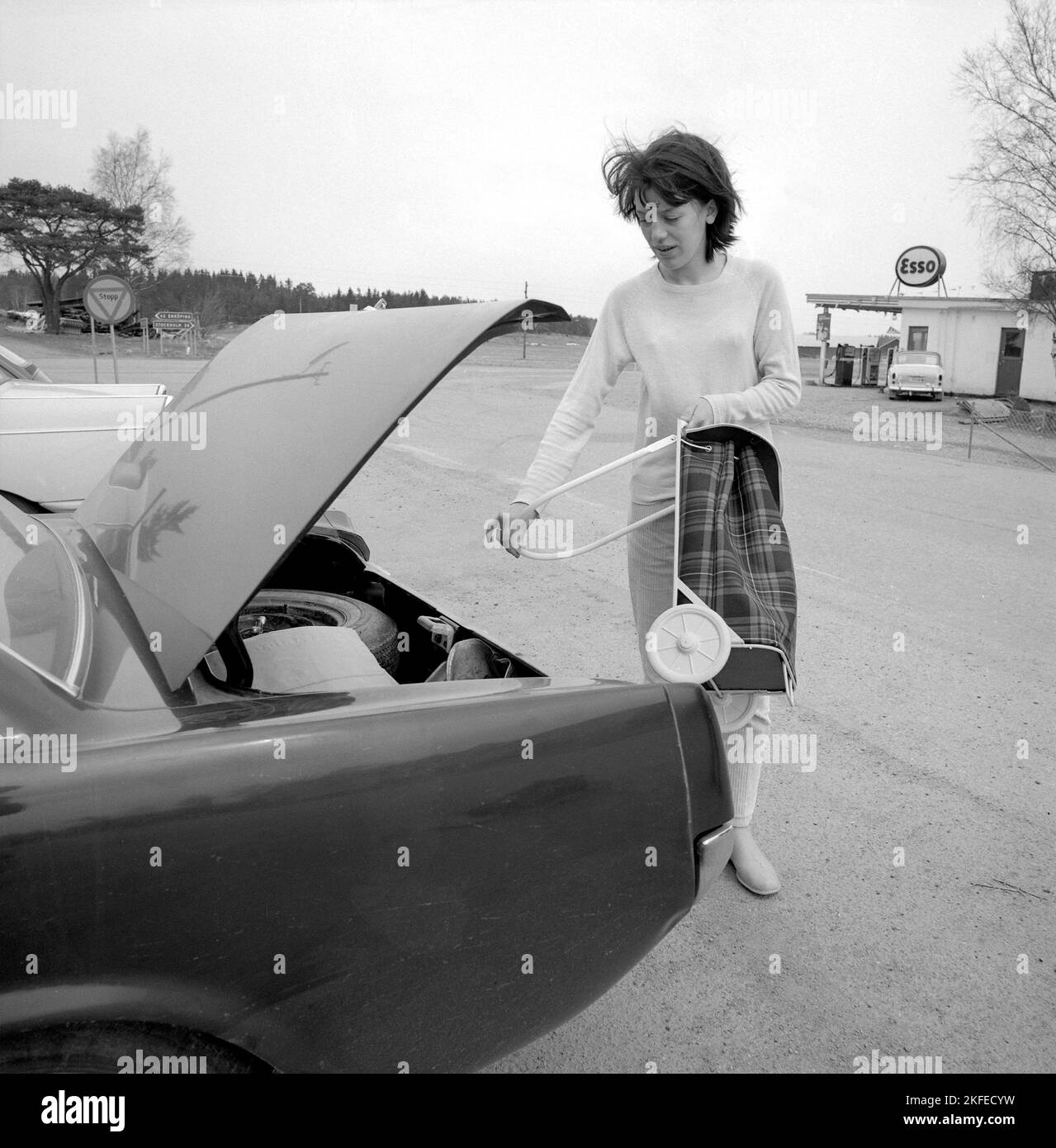 Einkaufen in der 1960s. Eine Dame hat ihr Auto im Supermarkt geparkt und nimmt ihren Warenkorb auf dem Parkplatz heraus. Ein Neuheitsartikel, der ursprünglich aus den USA kam. Schweden april 14 1966 Conard Ref. 5236 Stockfoto