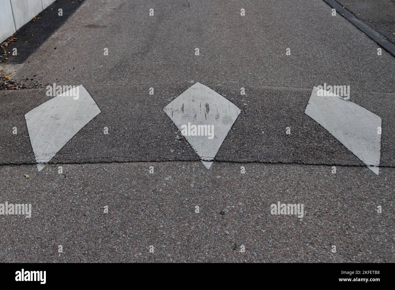 Weiße Diamant-Straßenmarkierung, um zu signalisieren, dass die Geschwindigkeit verringert wird Stockfoto