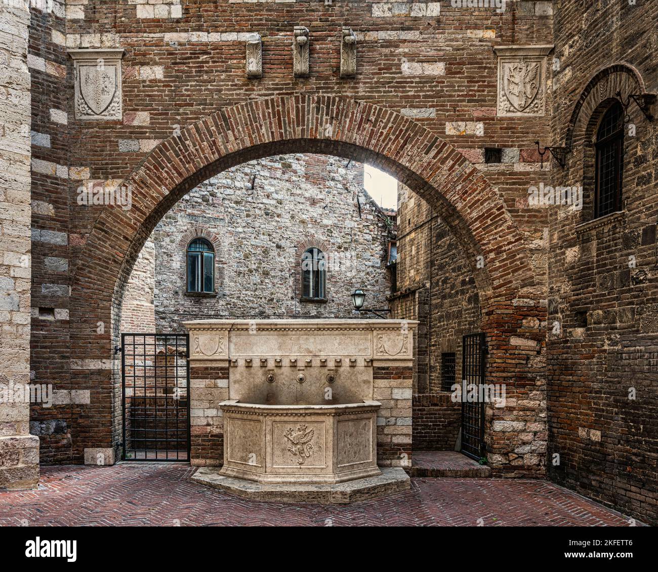 Der Brunnen wurde 1928 vom Architekten Pietro Angelini im mittelalterlichen Stil erbaut und befindet sich in der Via Maestà delle Volte unter einem Bogen aus dem 15.. Jahrhundert. Perugia Stockfoto