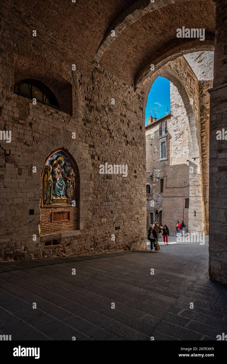 Via Maesta delle Volte. Überdachte Straßen im historischen Zentrum von Perugia. Links die Nische mit den Kunstwerken aus Keramik, die die Madonna repräsentieren Stockfoto