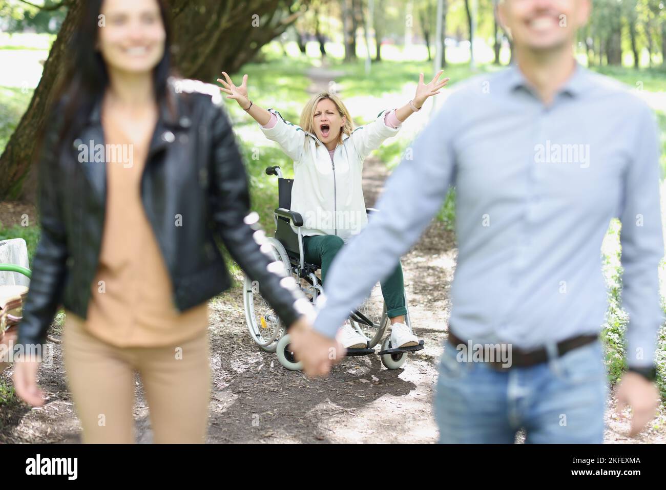 Glückliches Paar vergaß behinderte Frau im Rollstuhl im Freien. Stockfoto