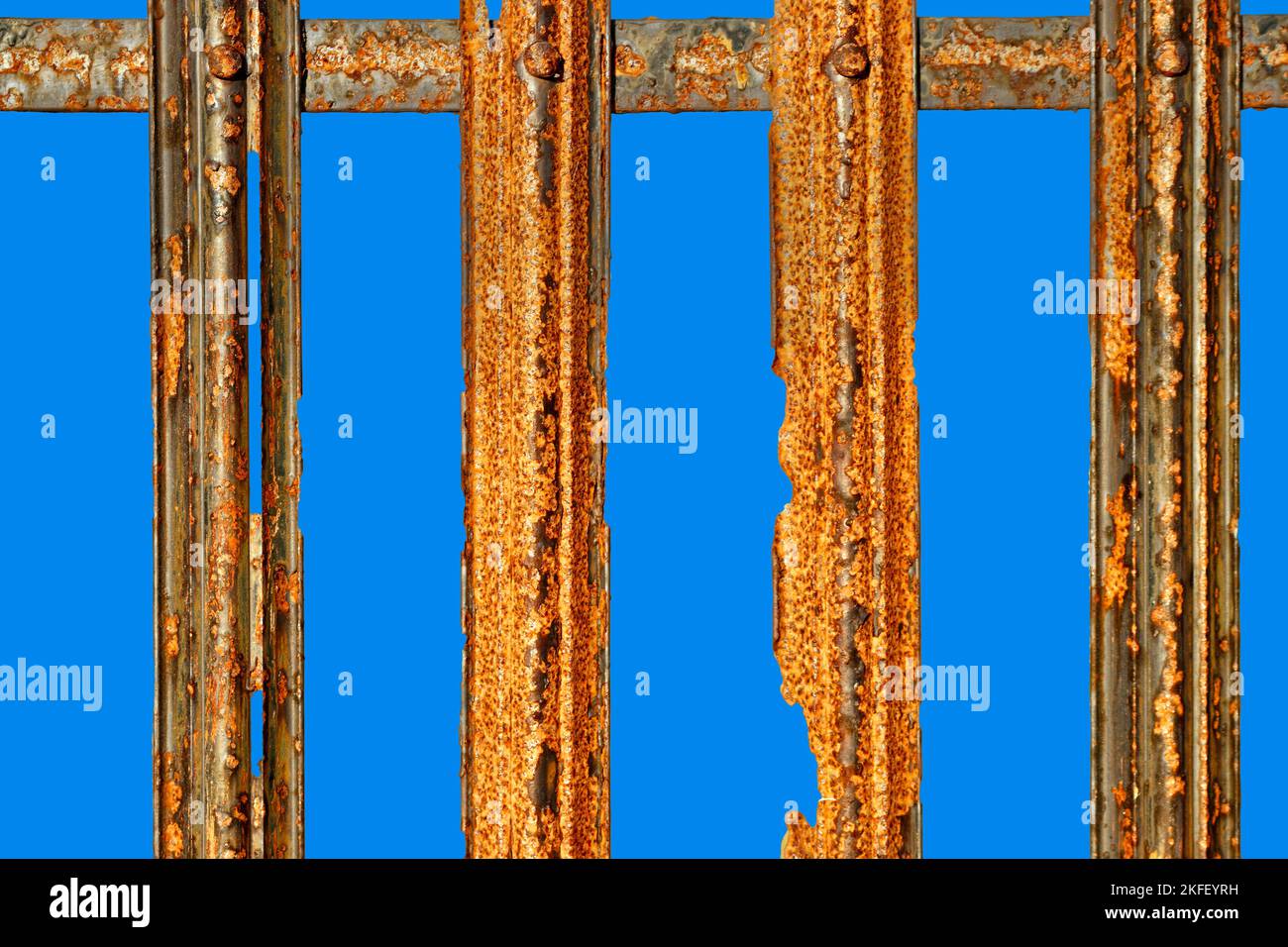 Alte verwitterte strukturierte verrostete Eisengeländer auf Blau Stockfoto