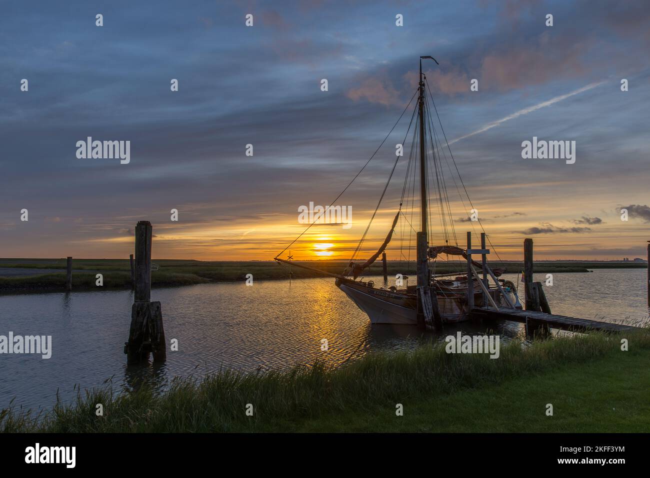 Sonnenaufgang mit Segelschiff am Süderhafen, Insel Nordstrand, Nordfriesland, Schleswig Holstein, Deutschland Stockfoto