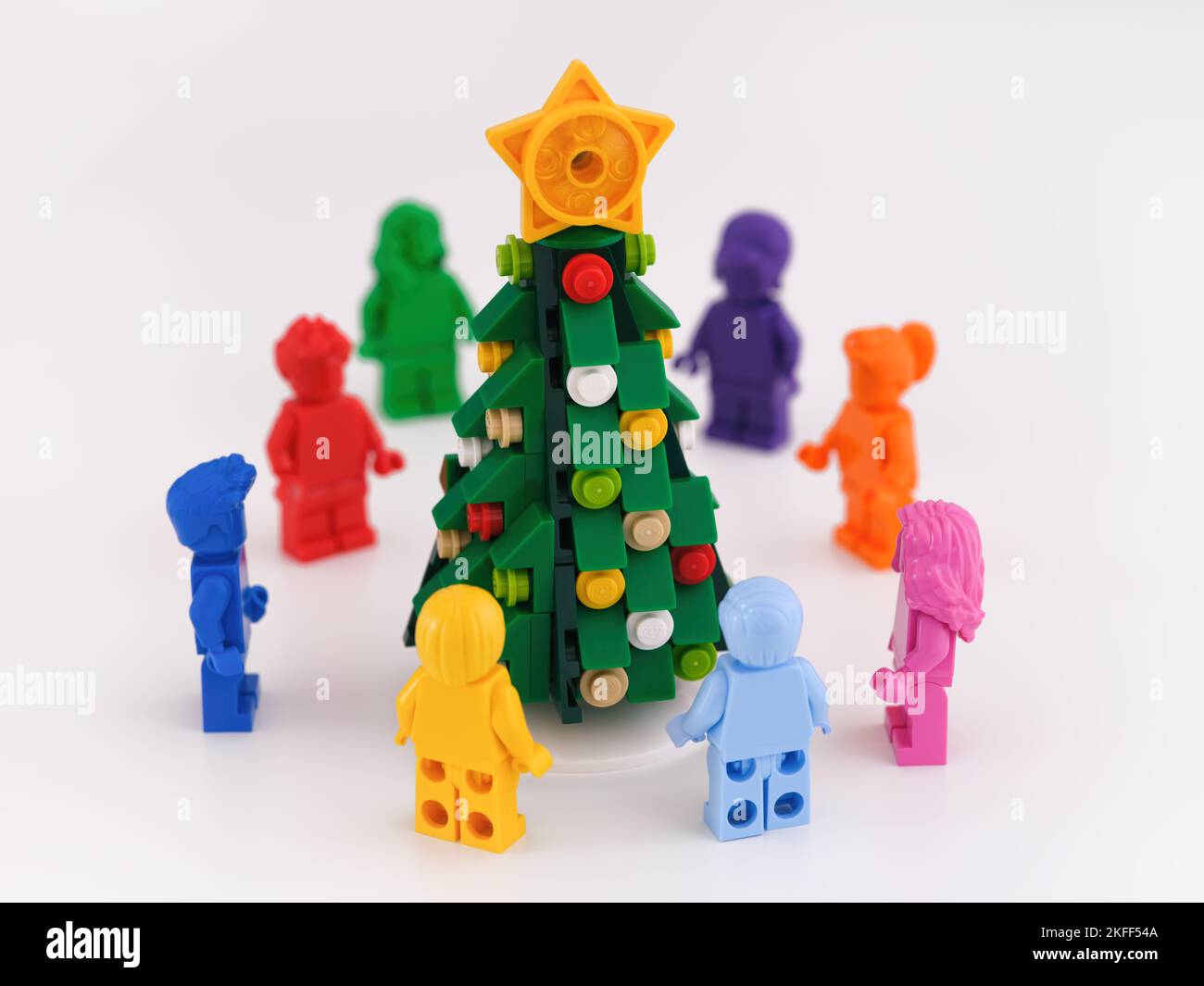 Tambow, Russische Föderation -15. November 2022 monochrome Lego-Minifiguren, die im Kreis um einen Weihnachtsbaum stehen. Weißer Hintergrund Stockfoto