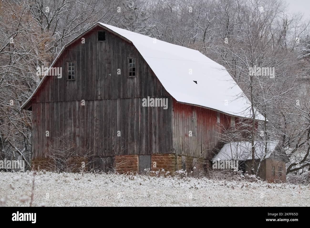 Eine alte, schneebedeckte Holzscheune im Winter Stockfoto
