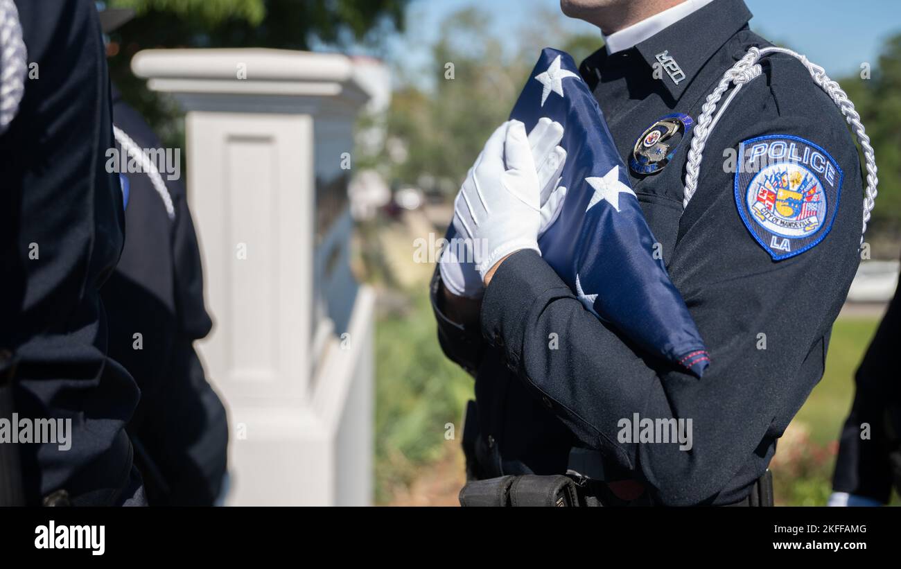 Ein Mitglied der Ehrengarde der Polizeibehörde Mandeville hält eine amerikanische Flagge, bevor in Mandeville, Louisiana, am 14. September 2022, ein permanentes Denkmal für den Mandeville Polizeihauptmann Vincent Liberto Jr. enthüllt wird. Liberto diente 10 Jahre in der US Marine Corps Reserve, bevor er ehrenhaft als Sergeant entlassen wurde. Er wurde am 20. September 2019 in der Dienstlinie angeschossen und getötet. An der Einweihung im Namen des Marine Corps nahm der US Marine Corps Col. Justin Ansel, stellvertretender Stabschef der Marine Forces Reserve G-3/5 und Bewohner von Mandeville Teil. . „Wir als Offiziere sind es Ameri schuldig Stockfoto