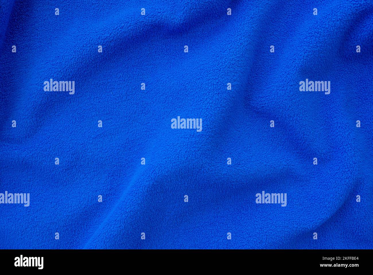 Hellblaues Fleece-Tuch. Zerknittertes, gefaltetes blaues Tuch als Hintergrund oder Hintergrund, Draufsicht Stockfoto