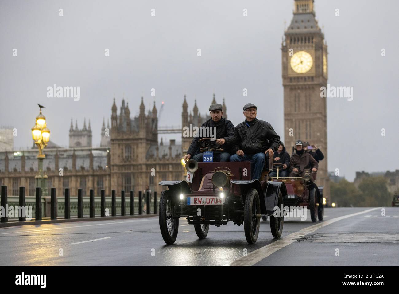 2022 London nach Brighton Veteran Car Run, die weltweit größte Versammlung von Oldtimern, macht sich an einem nassen Wintermorgen über die Westminster Bridge auf den Weg. Stockfoto