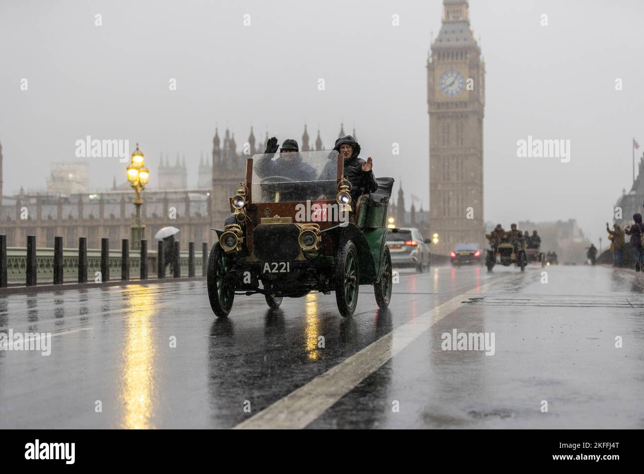 2022 London nach Brighton Veteran Car Run, die weltweit größte Versammlung von Oldtimern, macht sich an einem nassen Wintermorgen über die Westminster Bridge auf den Weg. Stockfoto