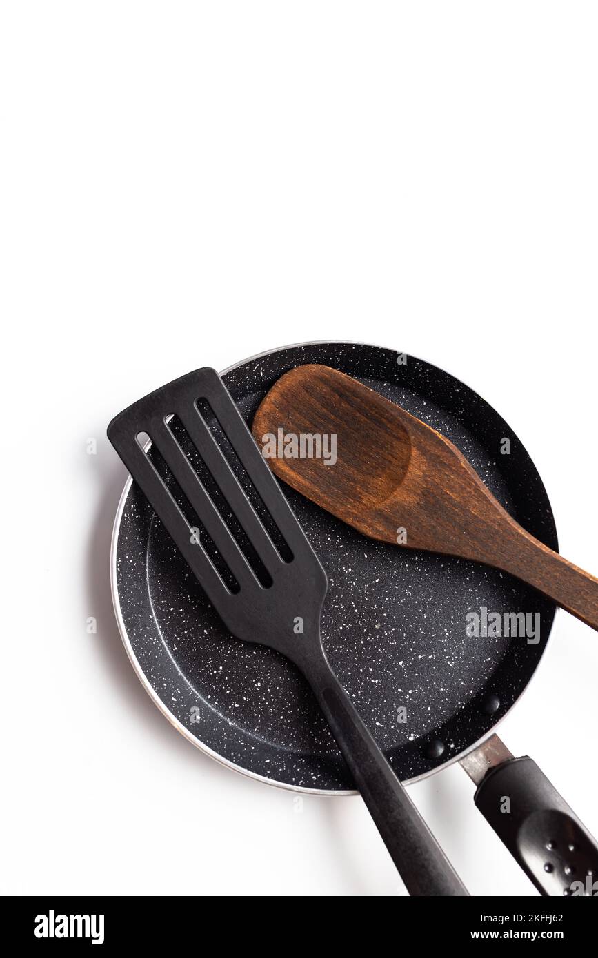 Eiserne Pfanne mit Holzspatel Draufsicht isoliert auf weißem Hintergrund Stockfoto