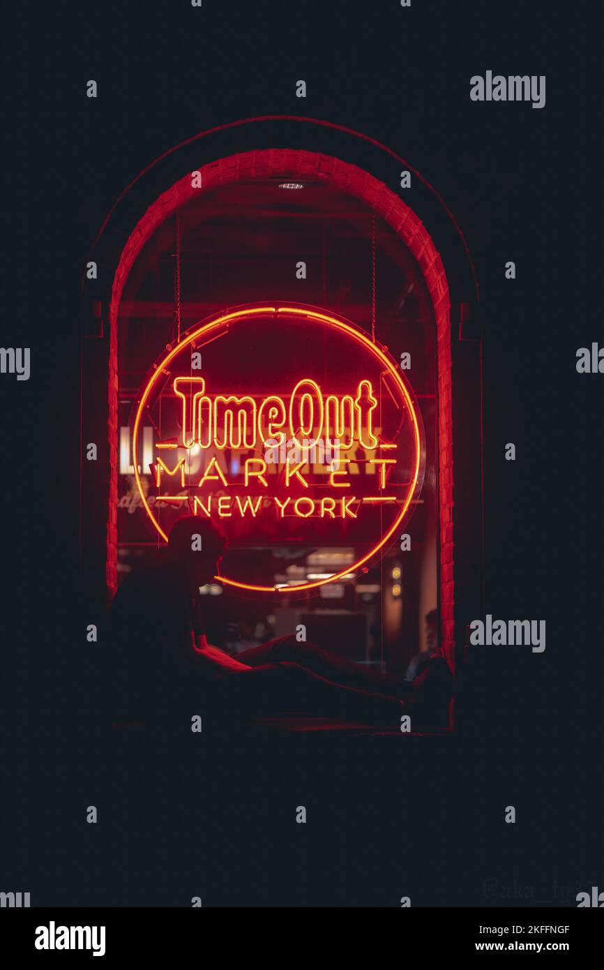 Eine vertikale Aufnahme des Time Out Market New York bei Nacht mit einer Silhouette Stockfoto
