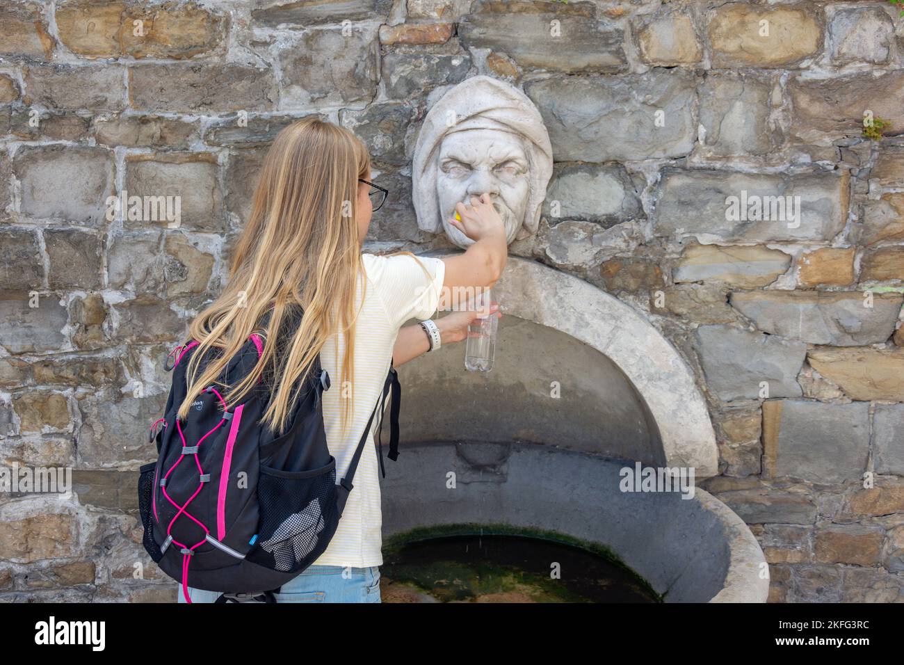 Junge Frau füllt Wasserflasche an der 17. Jahrhundert Wasserbrunnen, Preseren Platz (Piazza Prešeren), Prešernov trg, Koper, Slowenisch Istrien, Slowenien Stockfoto