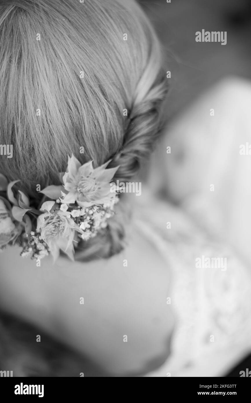 Die. Die Braut mit ihrem Brautkleid und Blumen im Haar an ihrem minimalistischen Hochzeitstag Stockfoto
