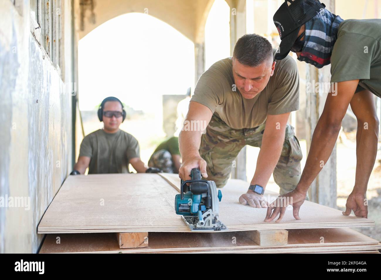 US-Militäringenieure und ein Mitglied der Timor-Leste Defence Force schnitten während der Renovierungsarbeiten an einer Schule im Rahmen von Pacific Angel 22-4 in Baucau, Timor-Leste, 15. September 2022, ein Holzblech. Die Operation, die vom 12. Bis 17. September geplant ist, konzentriert sich auf den Aufbau von Kapazitäten durch Öffentlichkeitsarbeit im Gesundheitswesen, Bauprojekte für zivilgesellschaftliche Maßnahmen und den Austausch von Fachexperten. Pacific Air Forces beteiligen sich an PAC ANGEL-Operationen, um die Interoperabilität zu fördern und auf etablierten Partnerschaften zwischen unseren militärischen Kräften und unseren Verbündeten und Partnern aufzubauen. Stockfoto