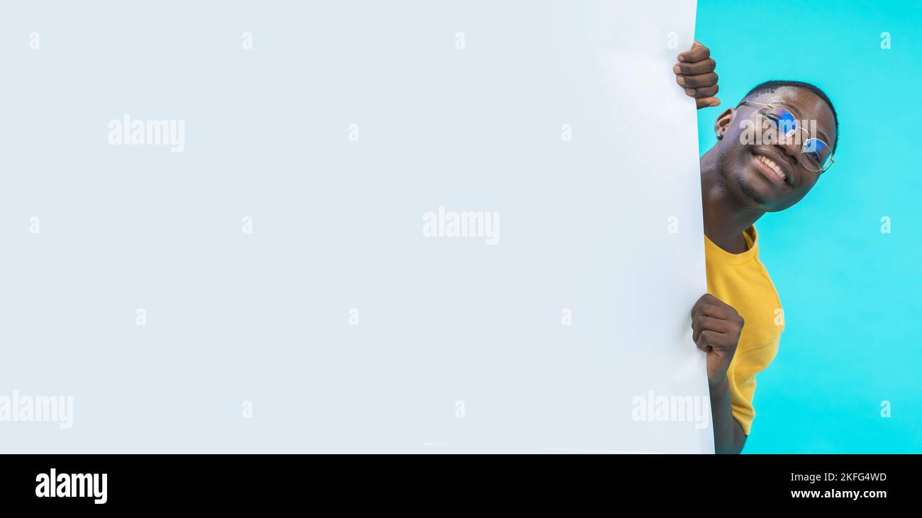 Banner mit einem schwarzen Jungen, der hinter einer weißen großen Tafel mit Platz für Text und Design herauskommt Stockfoto