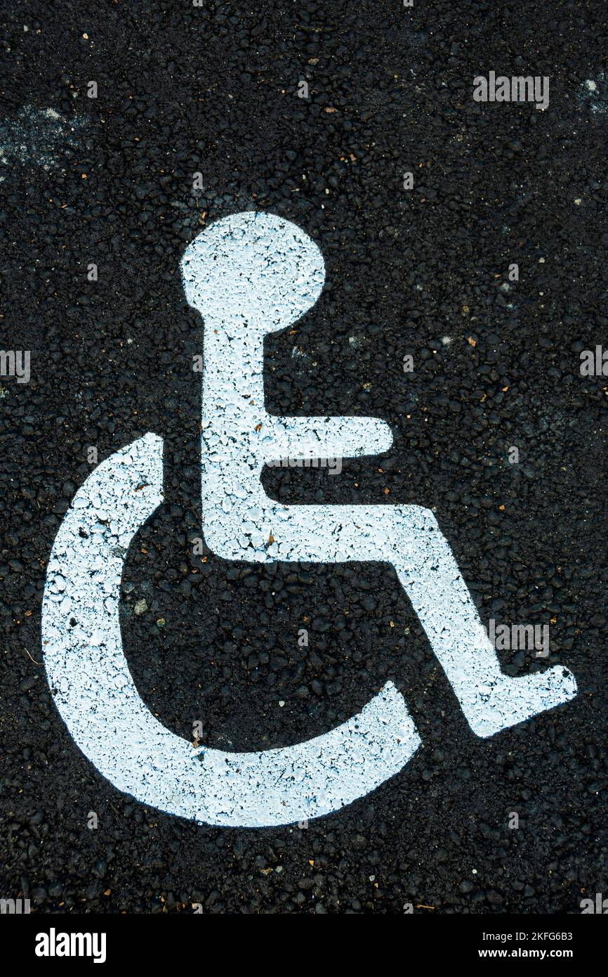Vertikale Aufnahme eines Behindertenschilds auf dem Asphalt Stockfoto