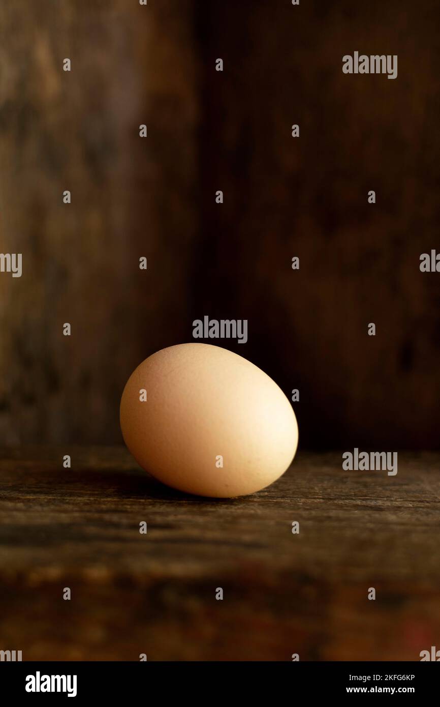 Vertikale Aufnahme eines Eies mit altem Holzhintergrund Stockfoto