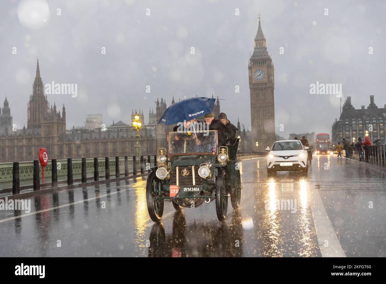 2022 London nach Brighton Veteran Car Run, die weltweit größte Versammlung von Oldtimern, macht sich an einem nassen Wintermorgen über die Westminster Bridge auf den Weg. Stockfoto
