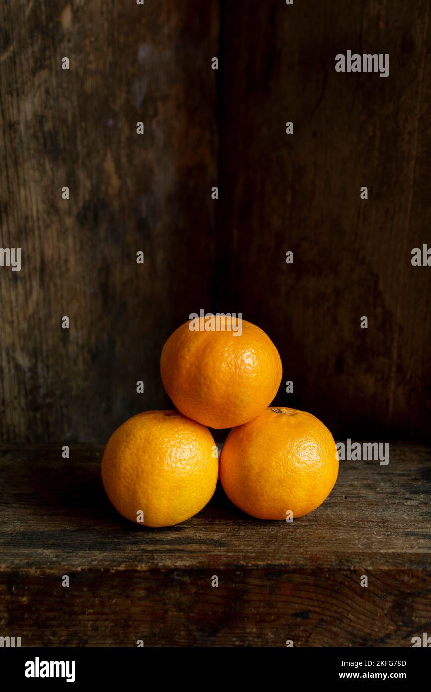 Vertikale Aufnahme von Mandarinen mit altem Holzhintergrund Stockfoto