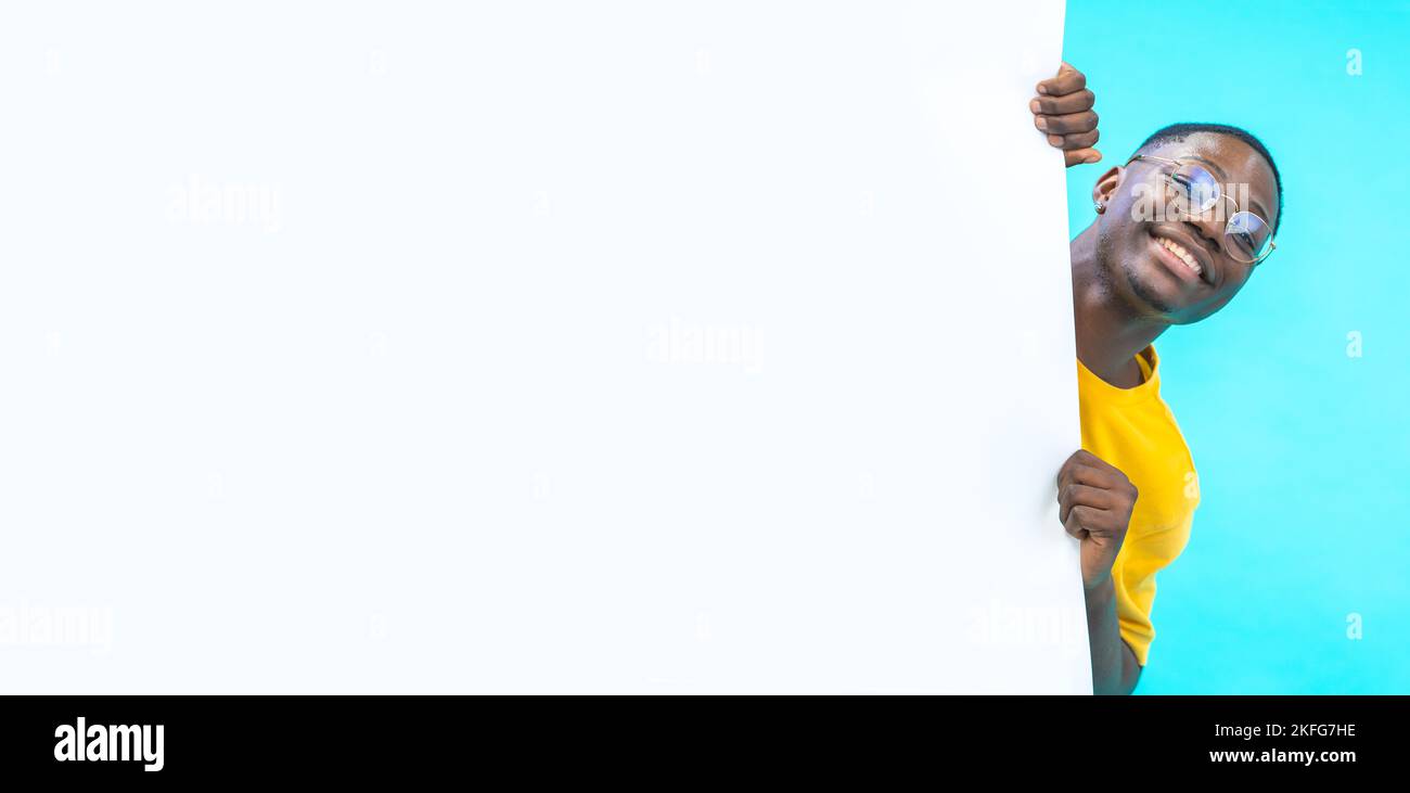 Banner mit einem schwarzen Jungen, der hinter einer weißen großen Tafel mit Platz für Text und Design herauskommt Stockfoto