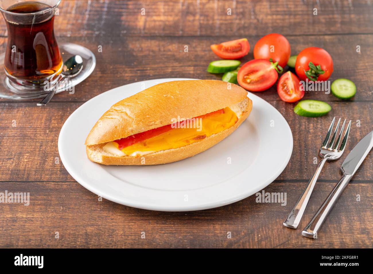 Drei Käsesandwich mit Tomaten und Gurken auf einem Tisch aus dunklem Stein Stockfoto