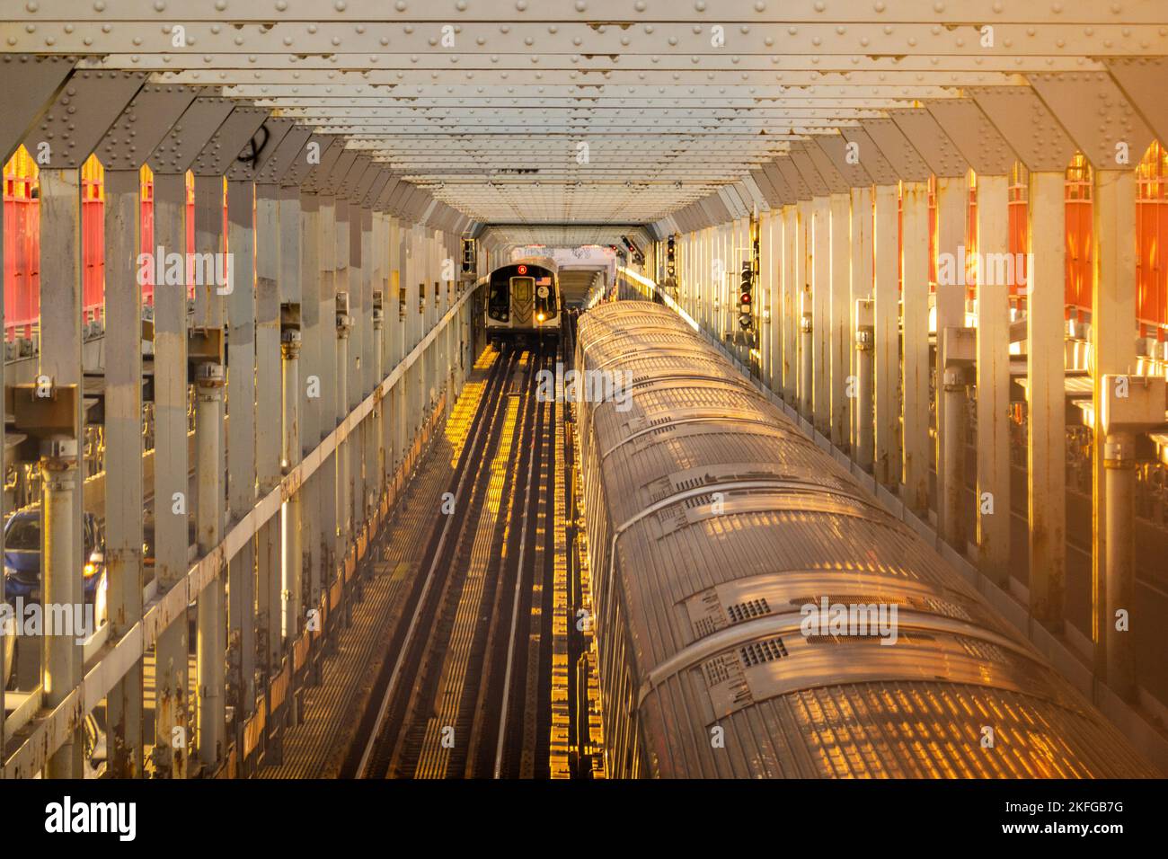 Zwei U-Bahn-Züge fahren auf der M-Linie auf der Williamsburg-Brücke in Brooklyn NYC aneinander vorbei Stockfoto