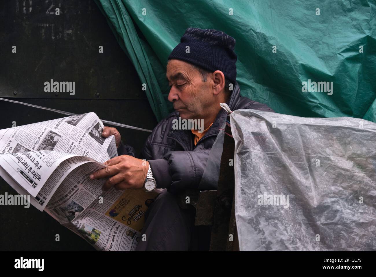 Gangtok, INDIEN, 22. Juni 2022, Mann mittleren Alters liest Zeitung am Straßenrand. Stockfoto