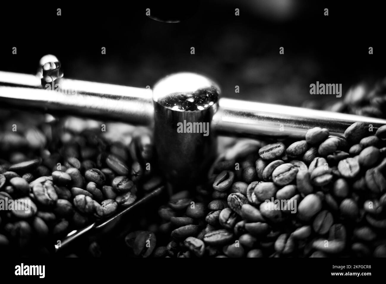 Kaffeebohnen in einer Kaffeemaschine, in dunklen Farben. Stockfoto