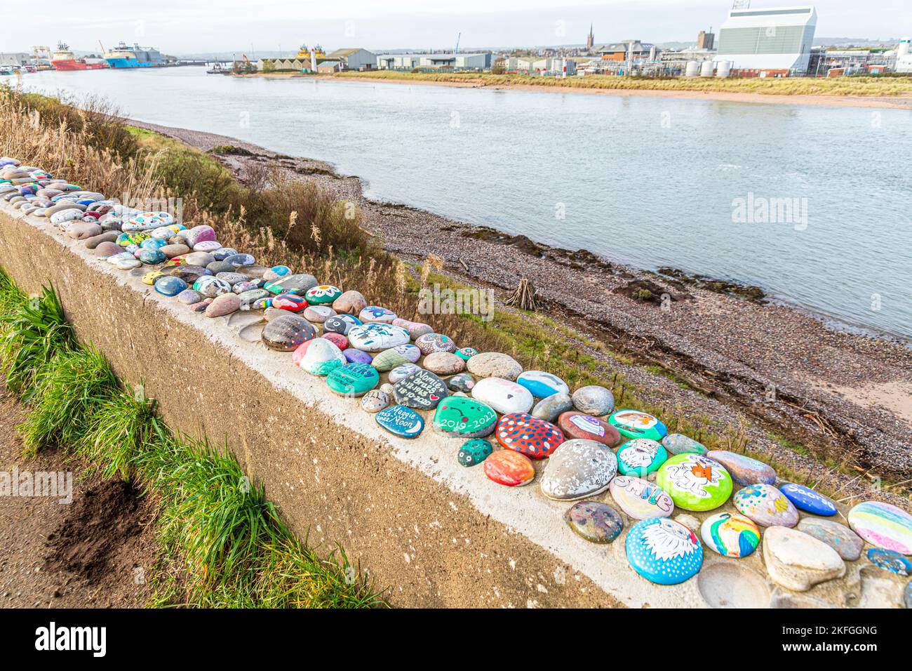 Gemalte Steine, die an einer Wand am Fluss South Esk in Ferryden, Montrose, Angus, Schottland, Großbritannien, befestigt sind Stockfoto
