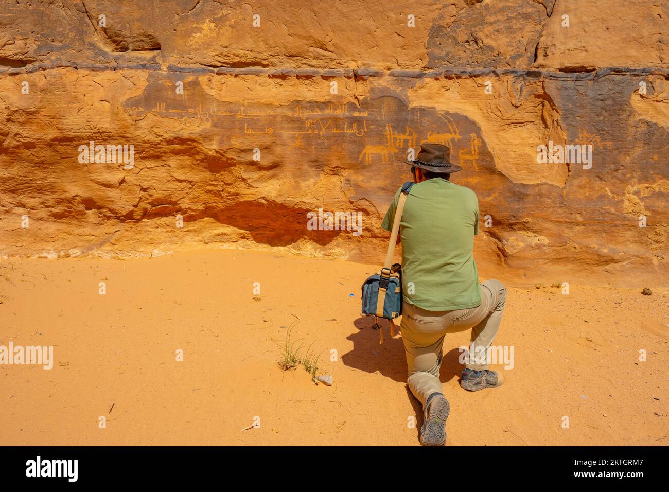 Touristen fotografieren alte Felskunst auf einer Klippe im Wadi Rum Jordan, Stockfoto