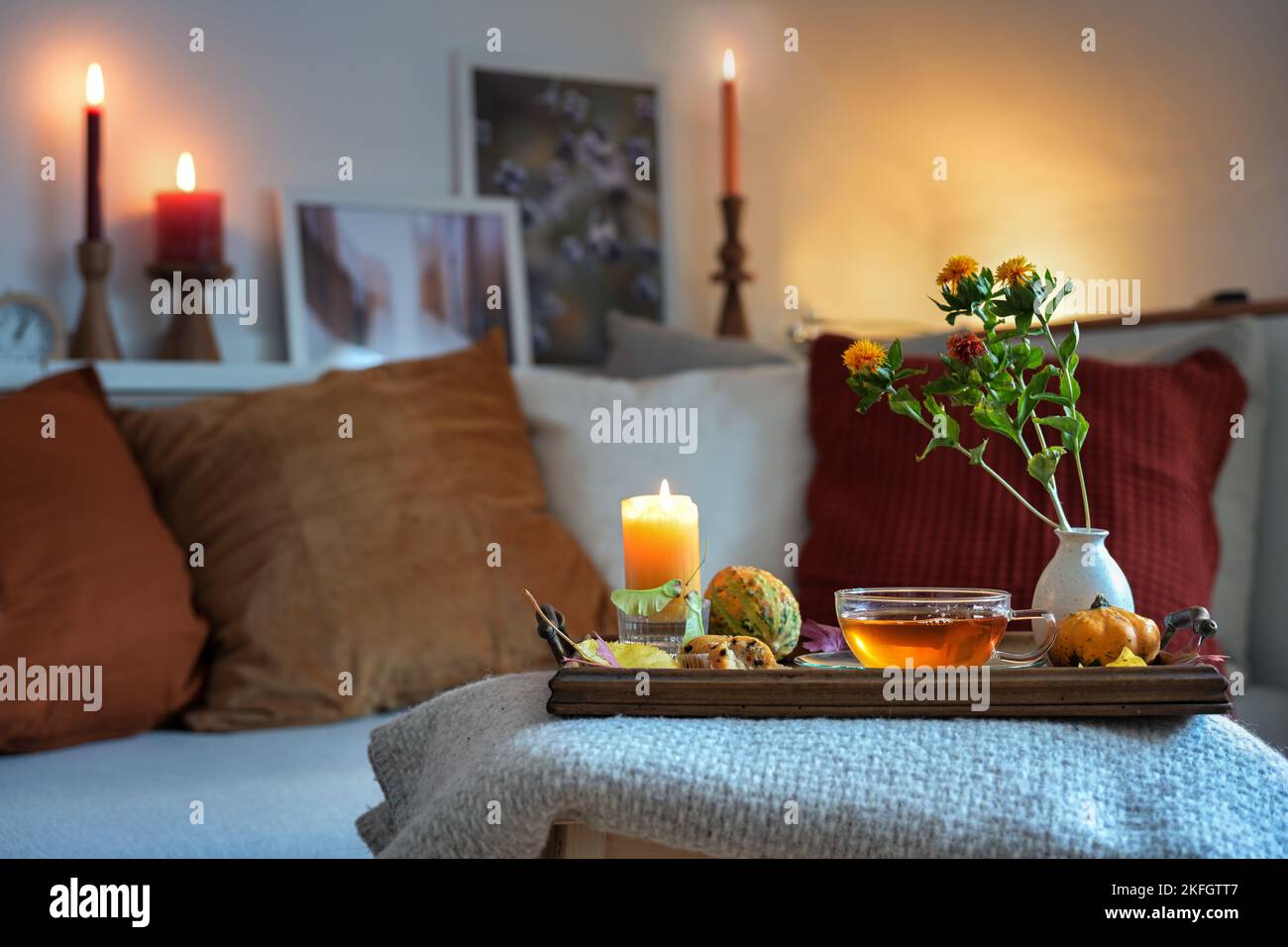 Entspannung mit Tee, Kerzen und Herbstdeko auf einem Tablet vor der Couch im gemütlichen Wohnzimmer, Kopierraum, ausgewählter Fokus, enge Tiefe Stockfoto Entspannung mit Tee, Kerzen und Herbstdeko auf einem Tablet vor der Couch im gemütlichen Wohnzimmer, Kopierraum, ausgewählter Fokus, enge Tiefe Stockfoto