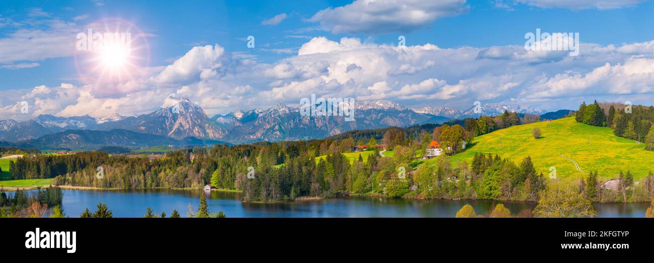 Panoramalandschaft mit See, Bergkette und Sonne am Himmel Stockfoto