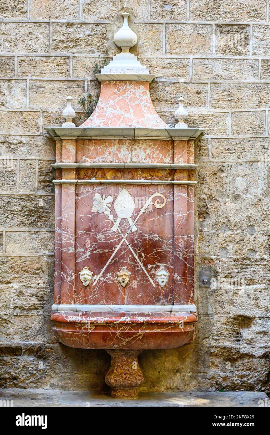 Mittelalterlicher Brunnen aus rotem Marmor in einer Kirchenmauer, Valencia, Spanien Stockfoto