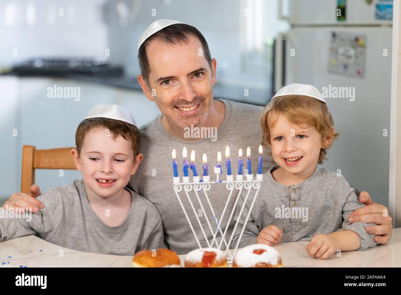 Vater und Söhne mit Menora feiern chanukka - jüdischer religiöser Feiertag Stockfoto